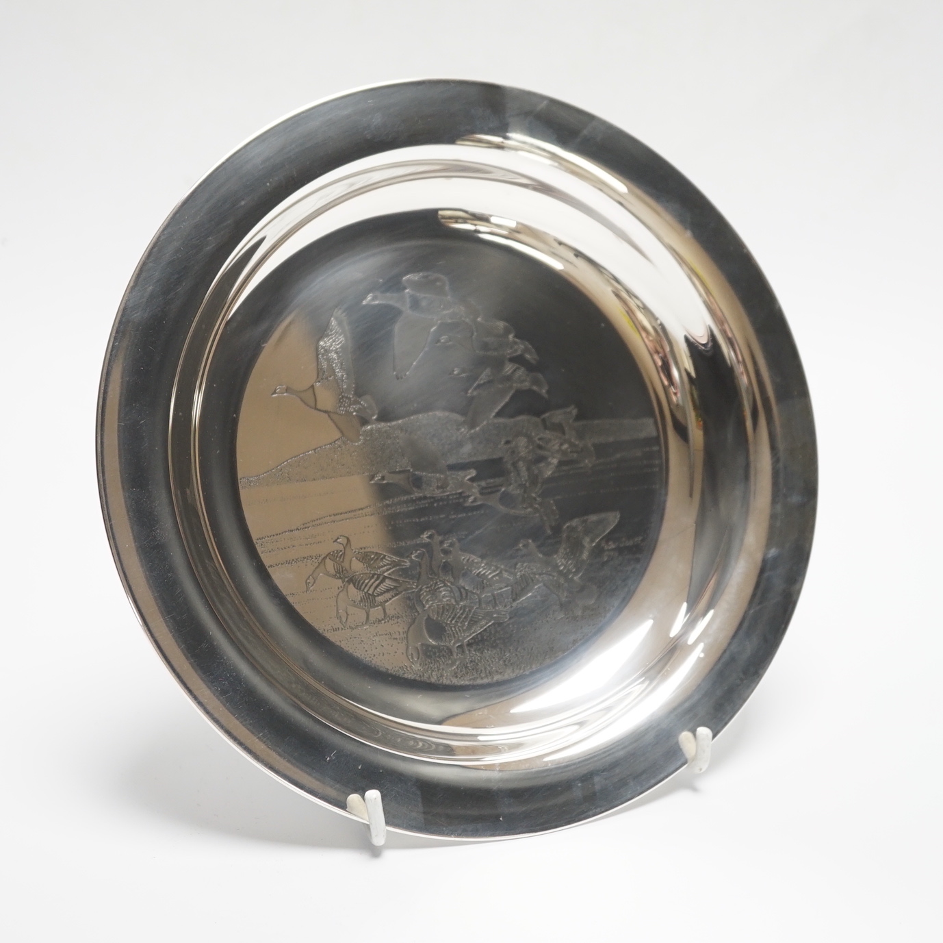 A boxed silver Peter Scott Christmas plate, 1974, depicting etched birds in flight, John Pinches, London 1974. Diameter 20.5cm, 5.9oz.